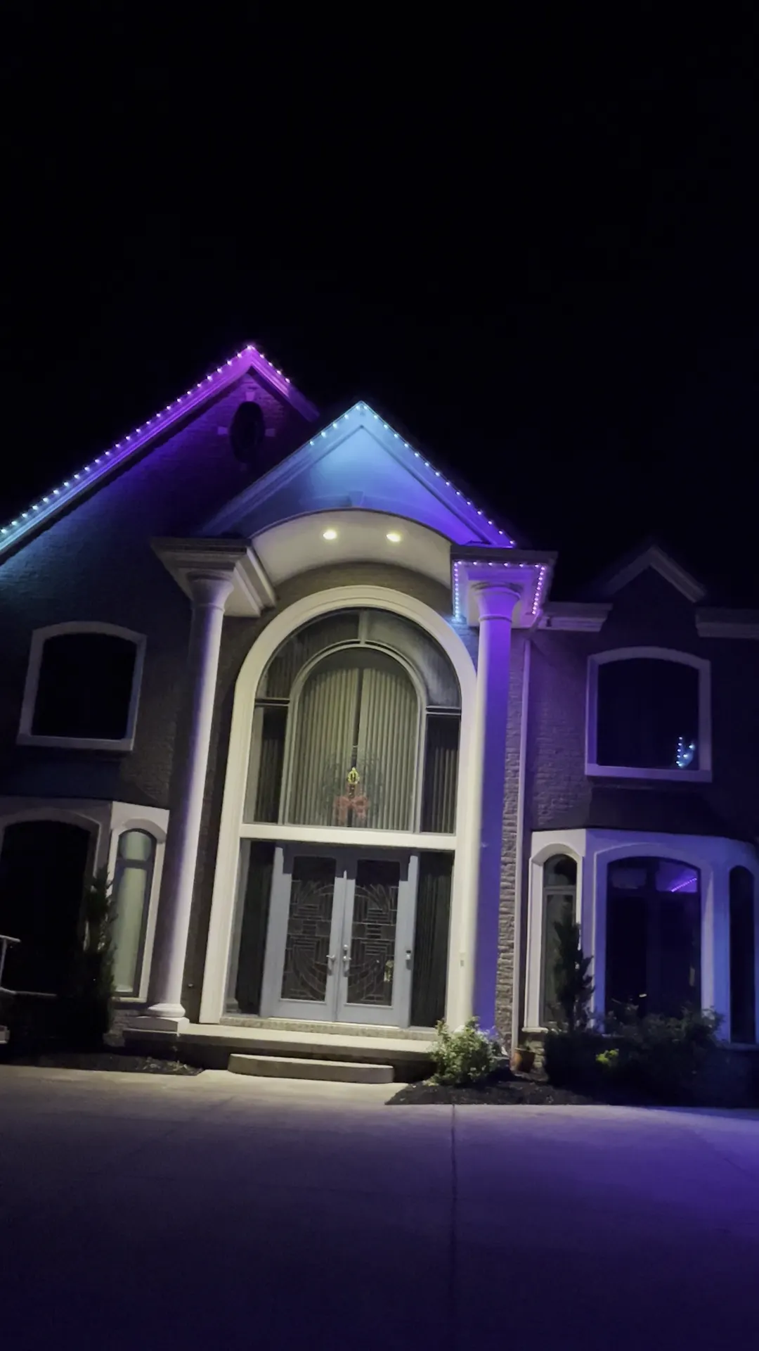 The same East Amherst home lit purple and blue