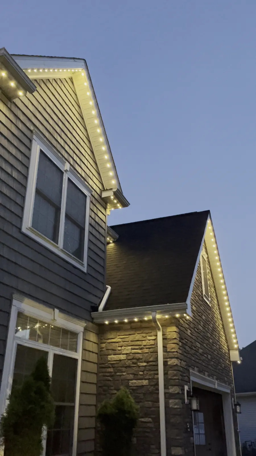 Stone gable at dusk with warm white permanent lights