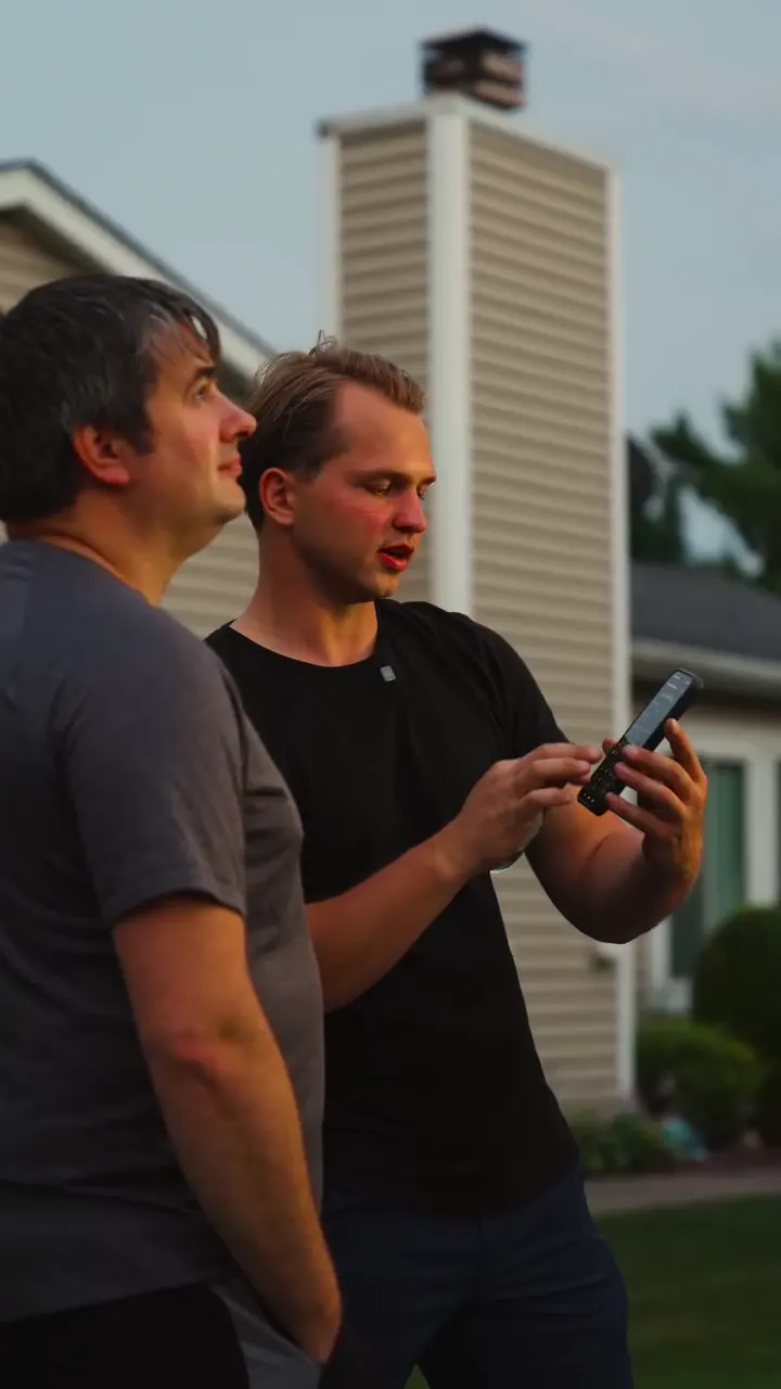 Edward, owner of Shinys Lighting, showing a Lancaster homeowner how to use the lighting app on his phone